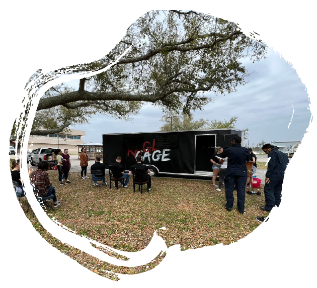the rage cage truck outside on a nice day with people relaxing on the yard